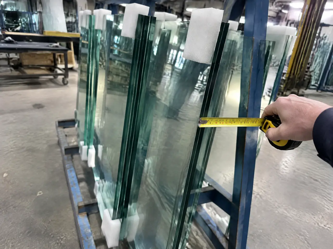 Tempered glass panels with foam corners on a steel rack